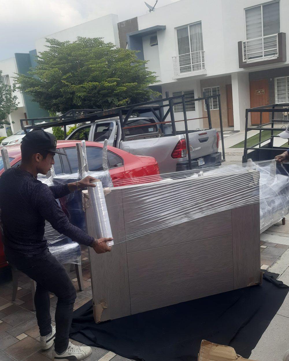 Equipo emplayando un mueble sobre colchoneta